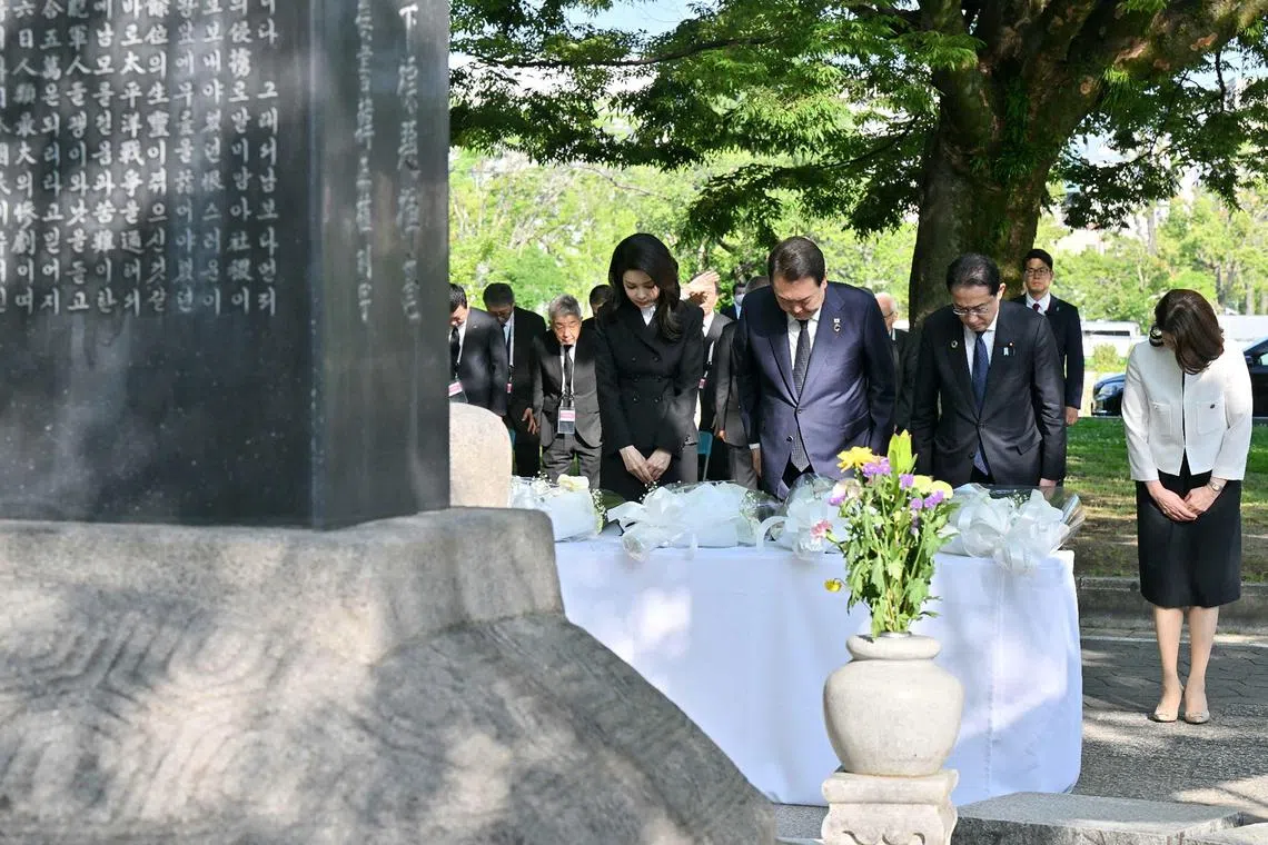 South Korea's Yoon Suk Yeol (2nd L), his wife Kim Keon Hee (L), Japan's Prime Minister Fumio Kishida (2nd R) and his wife Yuko Kishida (R) pay their respects during a visit to the "Monument in Memory of the Korean Victims of the A-bomb", near the Peace Park Memorial in Hiroshima on May 21, 2023, on the sidelines of the G7 Summit Leaders' Meeting. (Photo by JAPAN POOL / JIJI PRESS / AFP) / Japan OUT