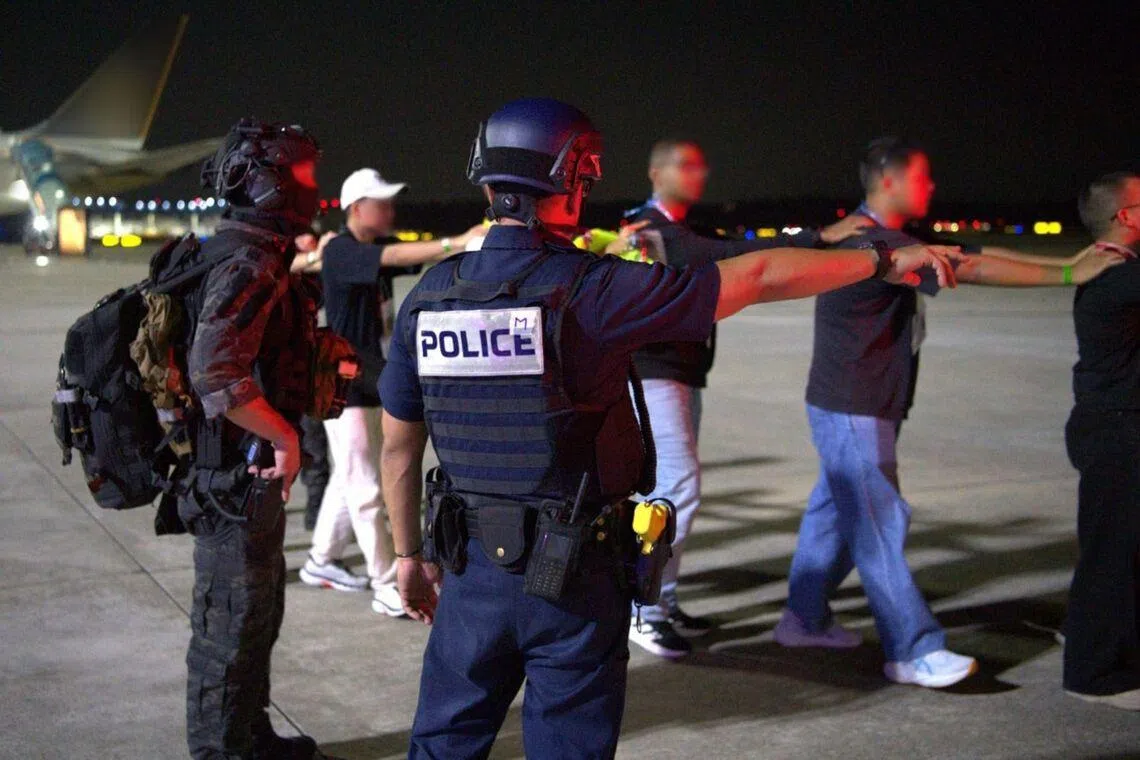 The police assisting with the simulated evacuation of hostages from a hijacked aircraft at Changi Airport.