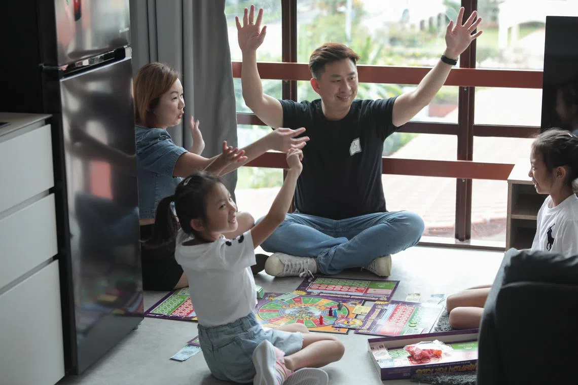ST20230130_202302712689/syfinancial/Ryan Chiong
Ms Jelene Sim, 41, and Mr Ernee Ong, 41, playing Cash Flow for Kids, a board game they use to teach financial literacy to their daughters Kaera (left), 8, and Kaelyn (right), 11.
Co-living startup Bespoke Habitats founders Mr Ernee Ong, 41, and Ms Jelene Sim, 41, and their daughters Kaelyn, 11, and Kaera, 8, at one of their properties, 406C Pasir Panjang, on Jan 30, 2023. The couple teaches their children about financial literacy using board games and bringing them around as they work.