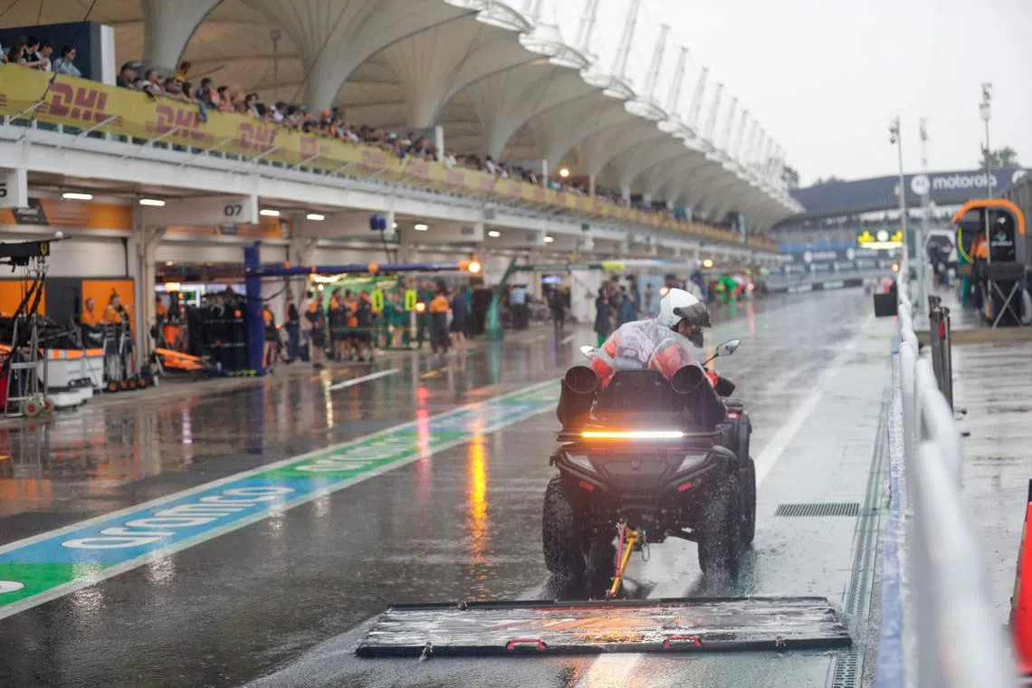 A marshal sweeping the pit lane after heavy rain fell at the Brazilian grand prix racetrack, forcing the postponement of the qualifying session on Nov 2.