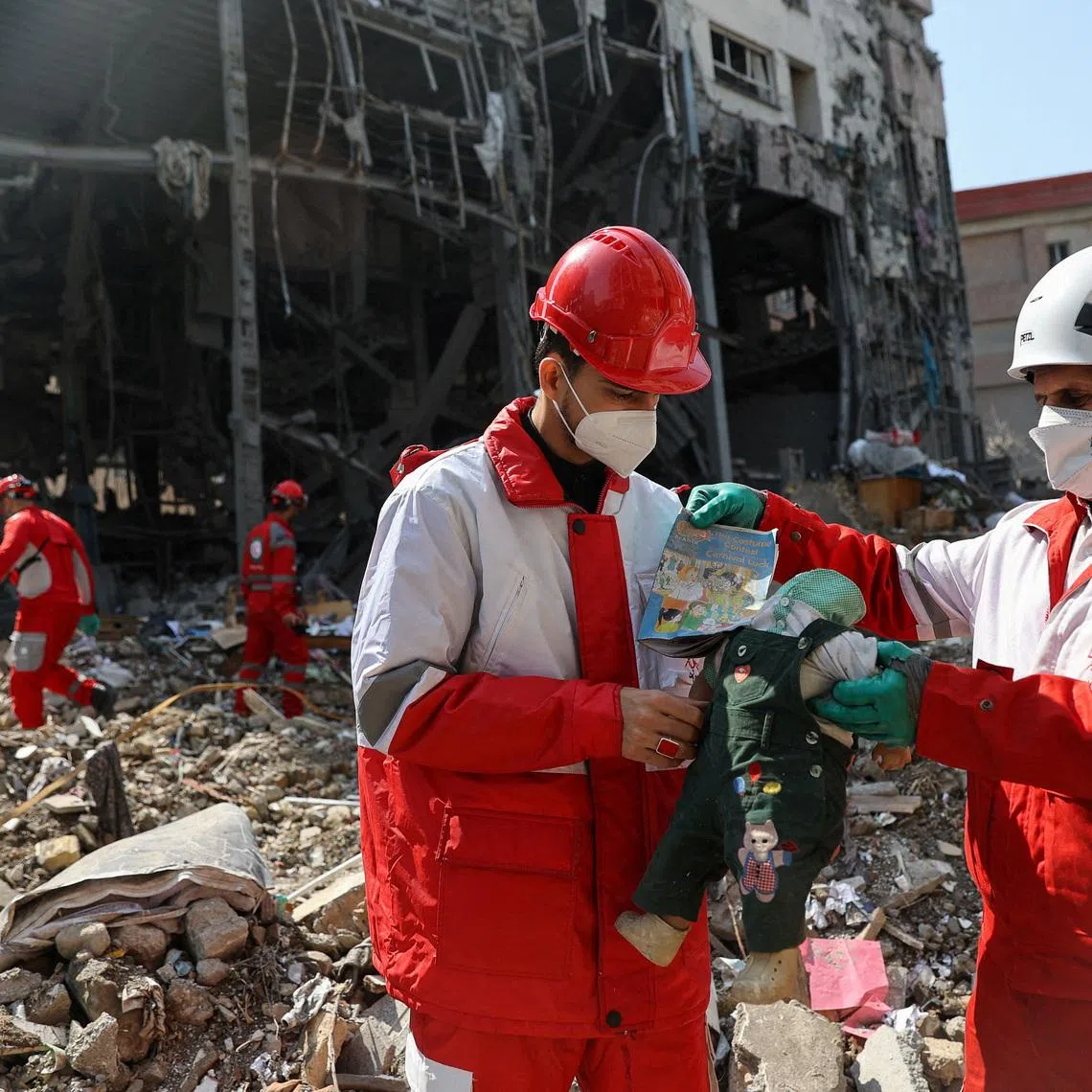 Members of a Red Crescent rescue team hold a doll, at the site of a building that was damaged by a strike, amid the U.S.-Israeli conflict with Iran, in Tehran, Iran, March 17, 2026. Majid Asgaripour/WANA (West Asia News Agency) via REUTERS