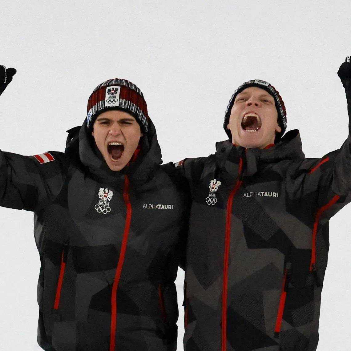 Milano Cortina 2026 Olympics - Ski Jumping - Men's Super Team Victory Ceremony - Predazzo Ski Jumping Stadium, Predazzo, Italy - February 16, 2026. Gold medallist's Jan Hoerl of Austria and Stephan Embacher of Austria celebrate on the podium during the men's super team victory ceremony REUTERS/Stephanie Lecocq