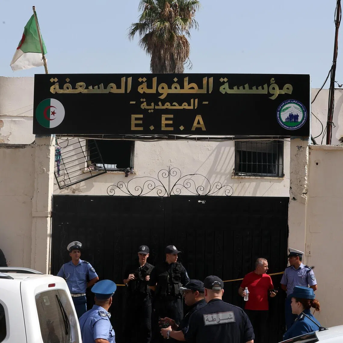 Police stand guard after a fire affected an orphanage in the Algiers suburb of Mohammadia, Algeria, on July 16.