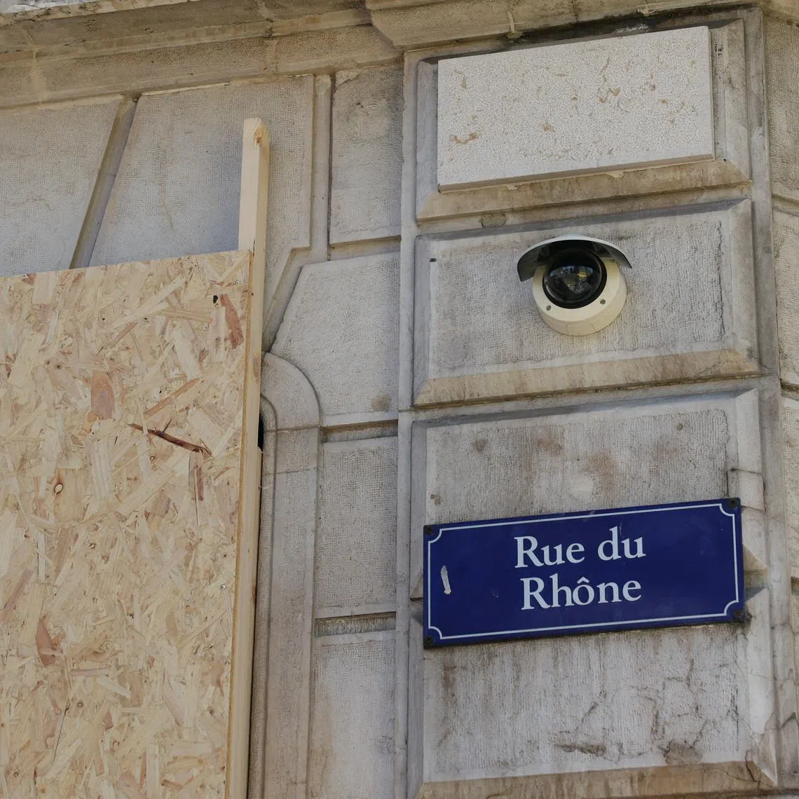 A wood panel to covering a shop windows is pictured next to a security camera at the Rue du Rhone ahead of a demonstration against the upcoming G7 summit in Evian-les-Bains, in Geneva, Switzerland, June 11, 2026. REUTERS/Denis Balibouse