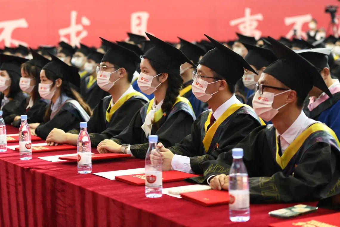 FILE PHOTO: Graduating students wearing face masks attend a commencement ceremony at Chongqing University of Posts and Telecommunications in Chongqing, China June 22, 2022. Cnsphoto via REUTERS   ATTENTION EDITORS - THIS IMAGE WAS PROVIDED BY A THIRD PARTY. CHINA OUT./File Photo