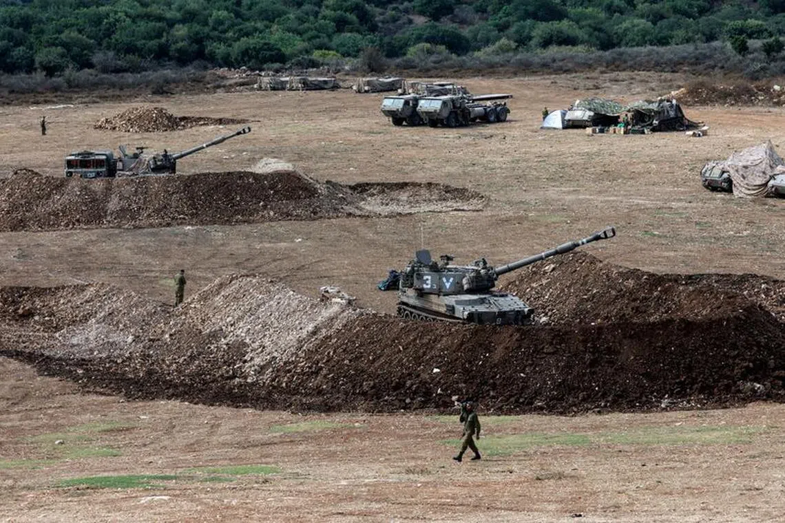An Israeli soldier walks past a tank near Israel's border with Lebanon, northern Israel, October 9, 2023. REUTERS/Ammar Awad