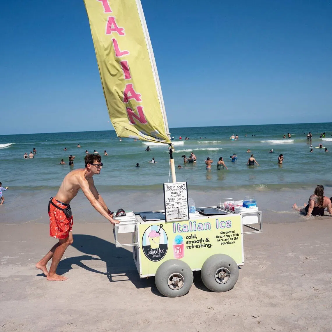 A worker pushing an Italian Ice cart at Carolina Beach, North Carolina, on July 3 amid a heatwave in parts of the US.