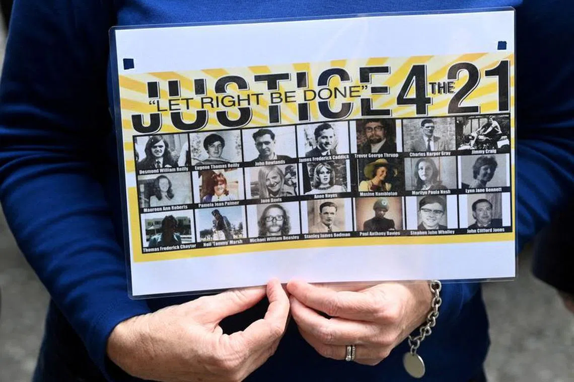 FILE PHOTO: A person holds a poster as campaigners and families of those affected during the period of conflict centred in Northern Ireland, known as The Troubles, hand a letter of protest against the British government's proposals  for possible legal proceedings into various killings, at Downing Street in London, Britain, September 6, 2021. REUTERS/Toby Melville/File Photo