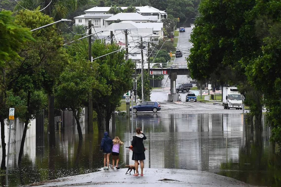 Residents looking at the flooding on their street in Newmarket, Brisbane, Australia, March 10, 2025. A cyclone has been downgraded to a "tropical low" but its impact is still being felt with a region reeling from major flooding with worse weather to come.