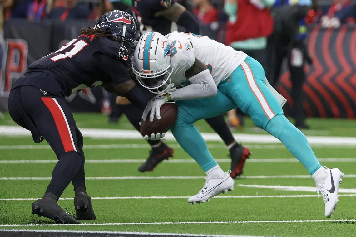 Dec 15, 2024; Houston, Texas, USA; Miami Dolphins wide receiver Grant DuBose (88) is tackled by Houston Texans safety Calen Bullock (21) in the third quarter at NRG Stadium. Miami Dolphins wide receiver Grant DuBose (88) was injured on the play and had to leave the game. Thomas Shea-Imagn Images/File Photo