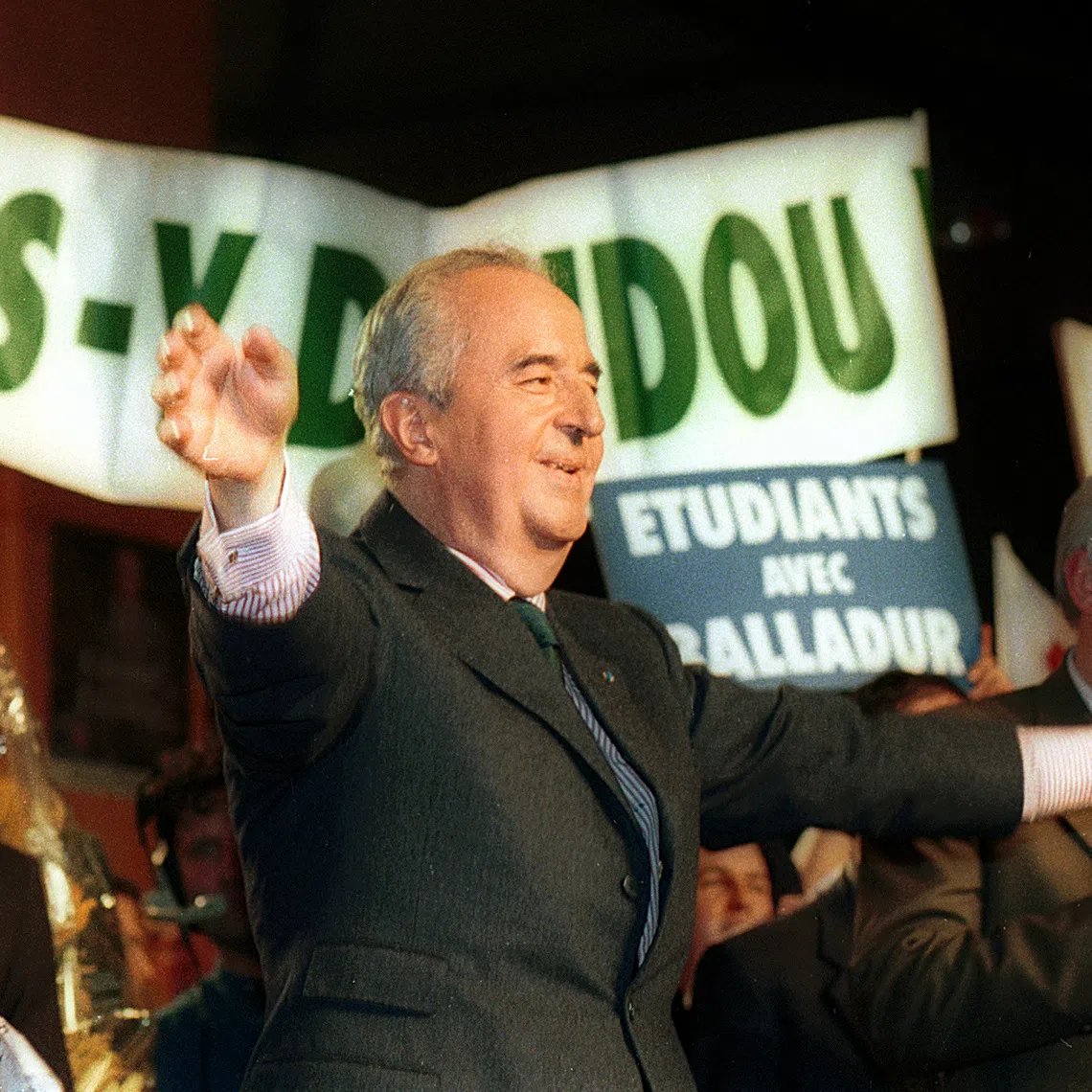FILE PHOTO: Edouard Balladur waves at the crowd during a campaign rally at Loudeac, Brittany, western France, March 28, 1995. Supporters hold a banner in the background saying 'Go Doudou,Go', the new family nickname of Balladur. REUTERS/Charles Platiau/File Photo