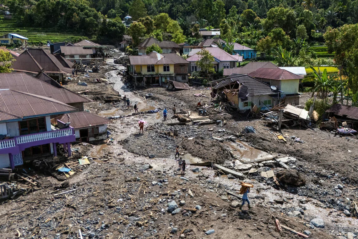 A drone view of local residents carrying their belongings recovered from their homes in an area affected by a deadly landslide following heavy rains in Malalak, Agam regency, West Sumatra province, Indonesia, December 3, 2025. REUTERS/Willy Kurniawan