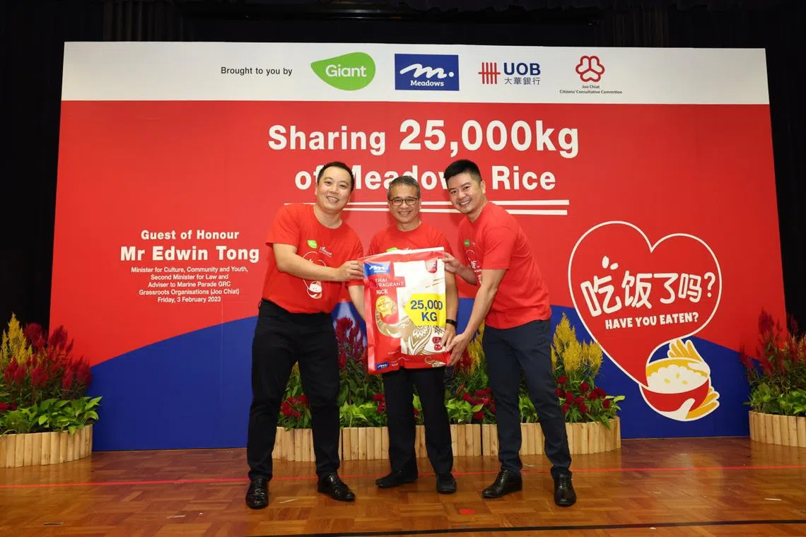 Minister for Culture, Community and Youth Edwin Tong (centre) receiving the donation of 25,000kg of rice from Mr Lee Yik Hun (left) of DFI Retail Group and Mr Luke Siew of UOB.