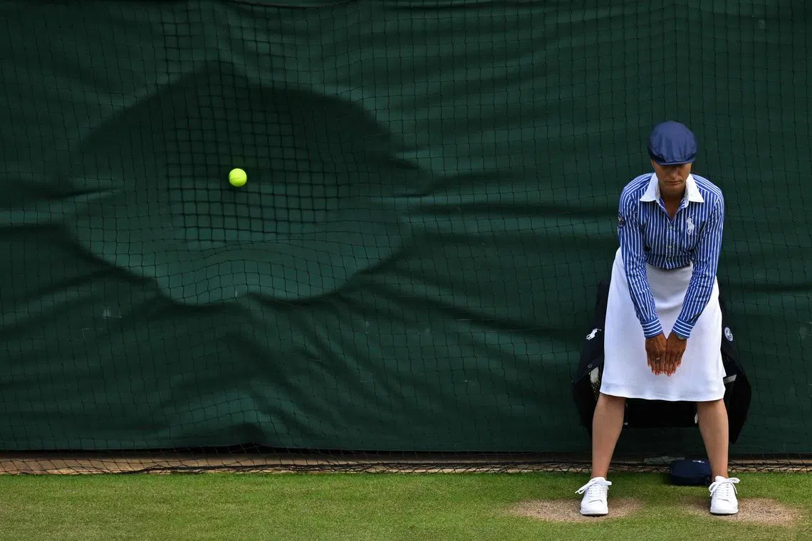 A line judge stands in position as a ball hits the back netting after a serve during the 2024 Wimbledon.