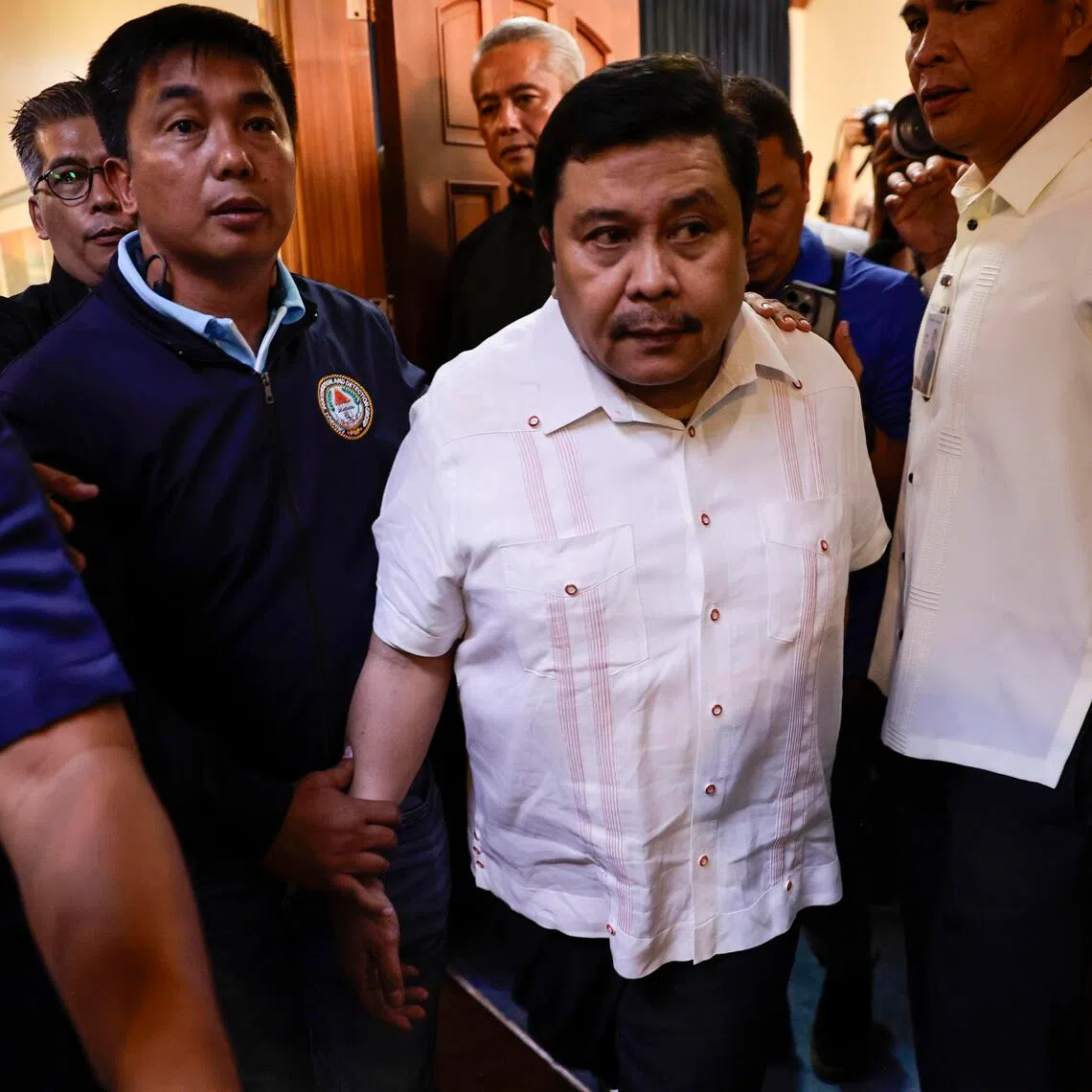 Philippine Senator Jose Estrada (centre) leaving the Senate in Pasay City to surrender to the police on June 1.