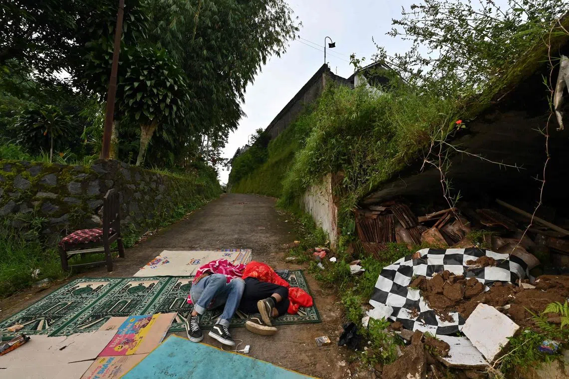 People sleep and rest on a street following a 5.6-magnitude earthquake that killed at least 162 people, with hundreds injured and others missing in Cianjur on Nov 22, 2022. 