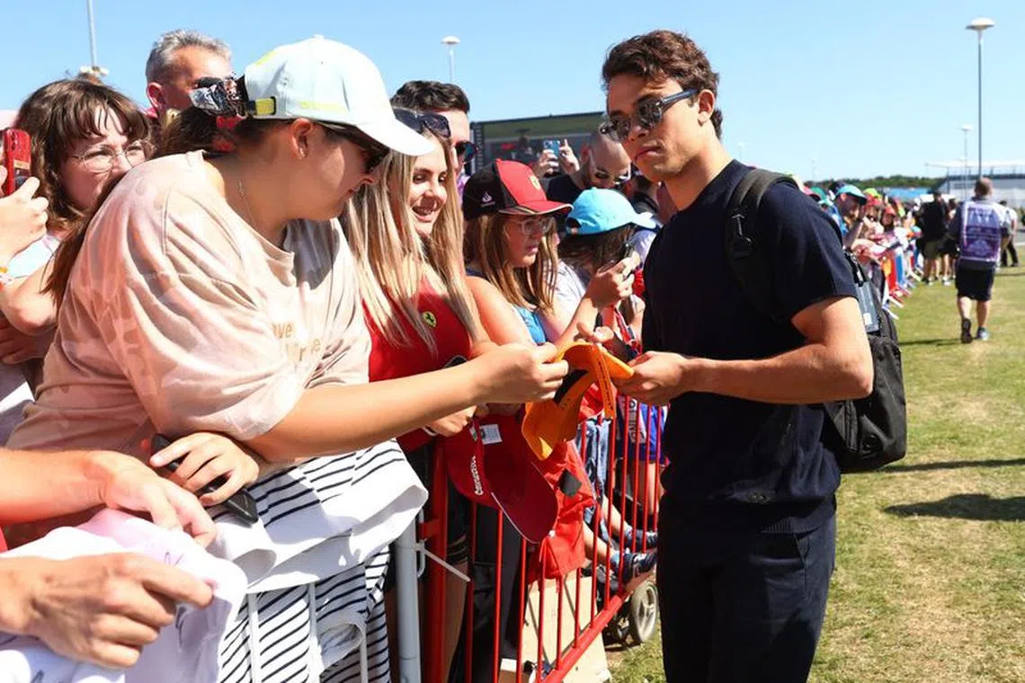 FILE PHOTO: Formula One F1 - British Grand Prix - Silverstone Circuit, Silverstone, Britain - July 7, 2023 AlphaTauri's Nyck de Vries signs autograph for fans ahead of practice REUTERS/Andrew Boyers/File Photo