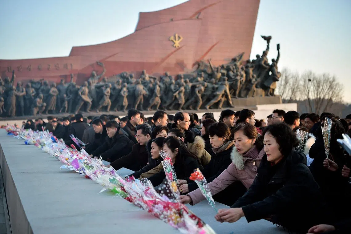 People laying flowers and paying their respects in front of statues of late North Korean leaders Kim Il Sung and Kim Jong Il at Mansu Hill to mark the 13th anniversary of the death of Kim Jong Il, the father of current leader Kim Jong Un, in Pyongyang on Dec 17, 2024.