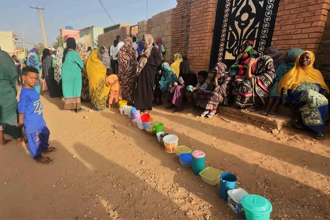 Residents wait to collect food in containers from a soup kitchen in Omdurman, Sudan March 11, 2024. Nearly five million people in the country are close to famine as Sudan's civil war passes the one-year mark. REUTERS/El Tayeb Siddig/ File Photo