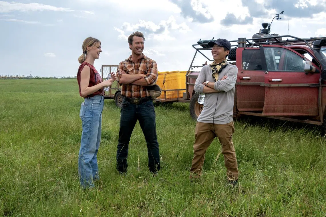 (from left) Daisy Edgar-Jones, Glen Powell, and Director Lee Isaac Chung on the set of Twisters. 