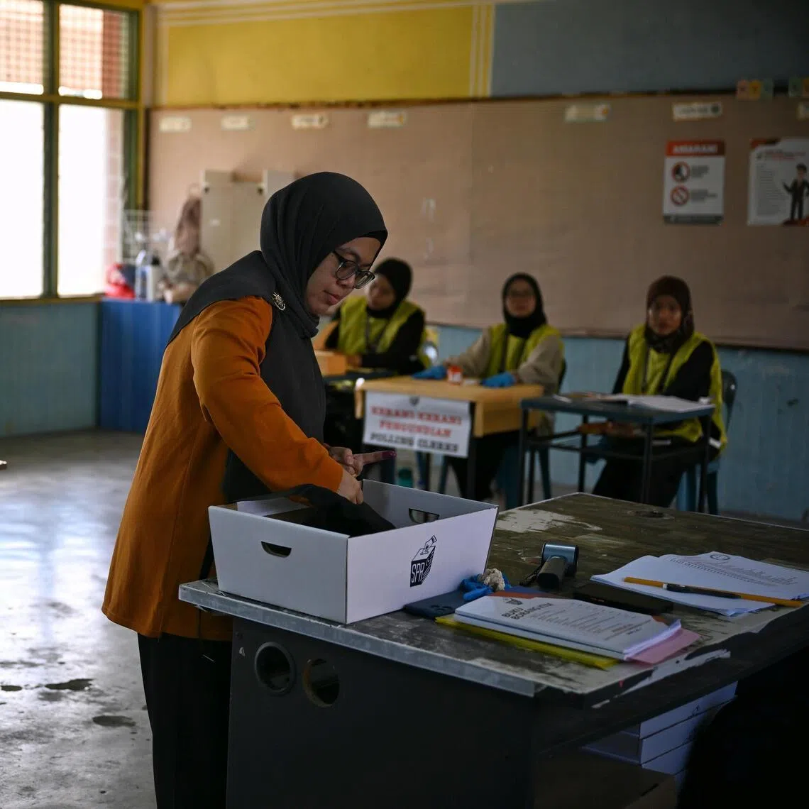 A voter casting a ballot at Tanjung Puteri Primary School in Larkin, Johor, on polling day, July 11.