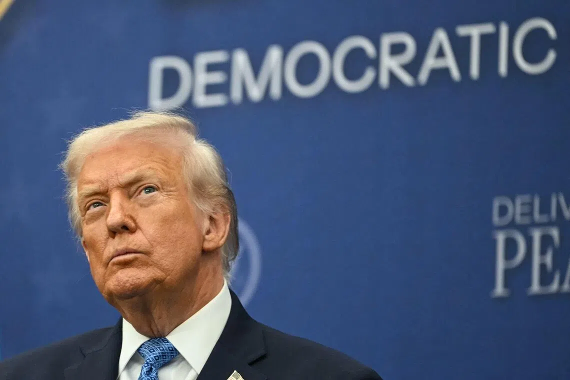 TOPSHOT - US President Donald Trump attends the signing ceremony of a peace deal with the President of Rwanda Paul Kagame and the President of the Democratic Republic of the Congo Felix Tshisekedi at the United States Institute of Peace in Washington, DC, on December 4, 2025. Trump on Thursday brings the leaders of Rwanda and the Democratic Republic of Congo together to endorse a deal that Trump has hailed as his latest peace triumph despite ongoing violence on the ground. Trump hopes the agreement will pave the way for the United States to gain access to critical minerals in the eastern DRC, a violence-torn region home to many of the key ingredients in modern technologies such as electric cars. (Photo by ANDREW CABALLERO-REYNOLDS / AFP)