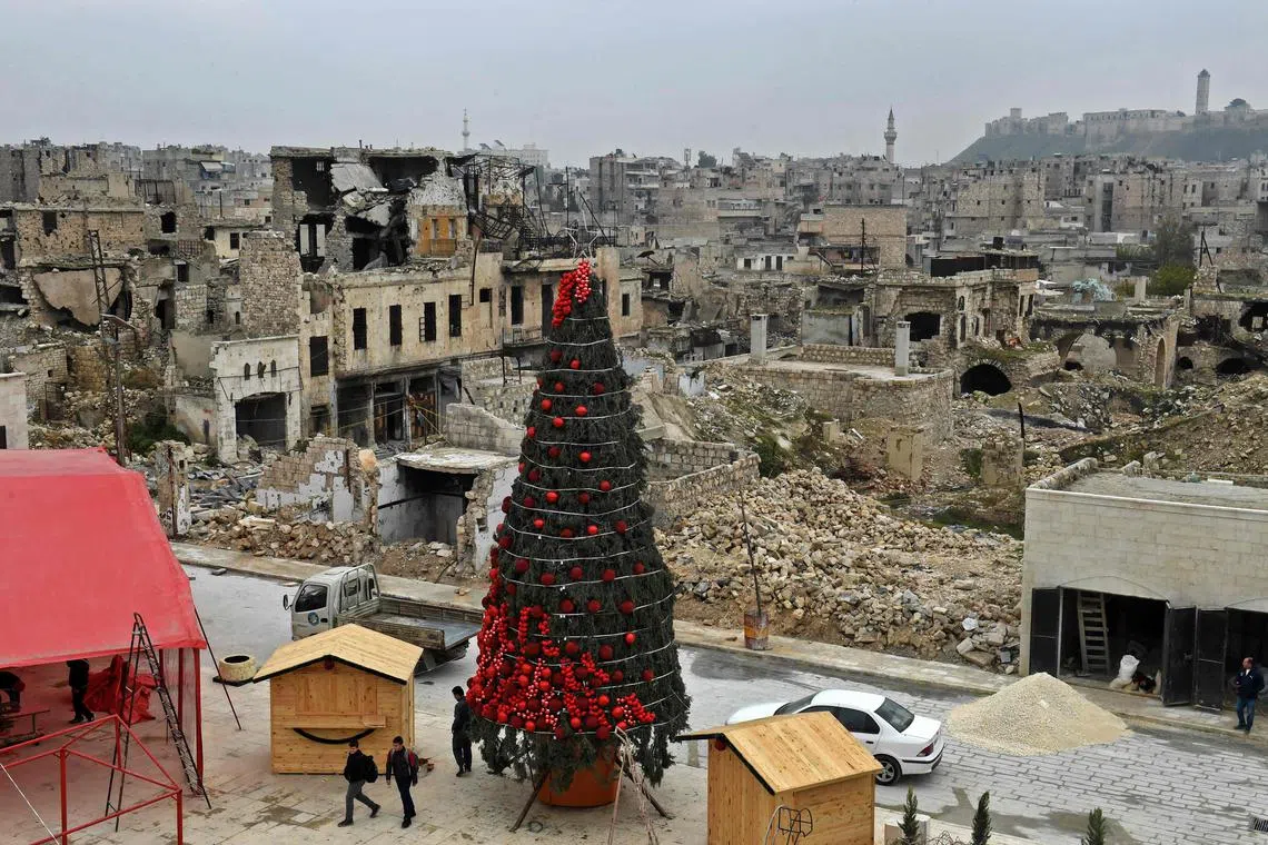 Workers set up a Christmas tree at al-Hatab square, one of the oldest in Syria's northern city of Aleppo, on Dec 12, 2022. 