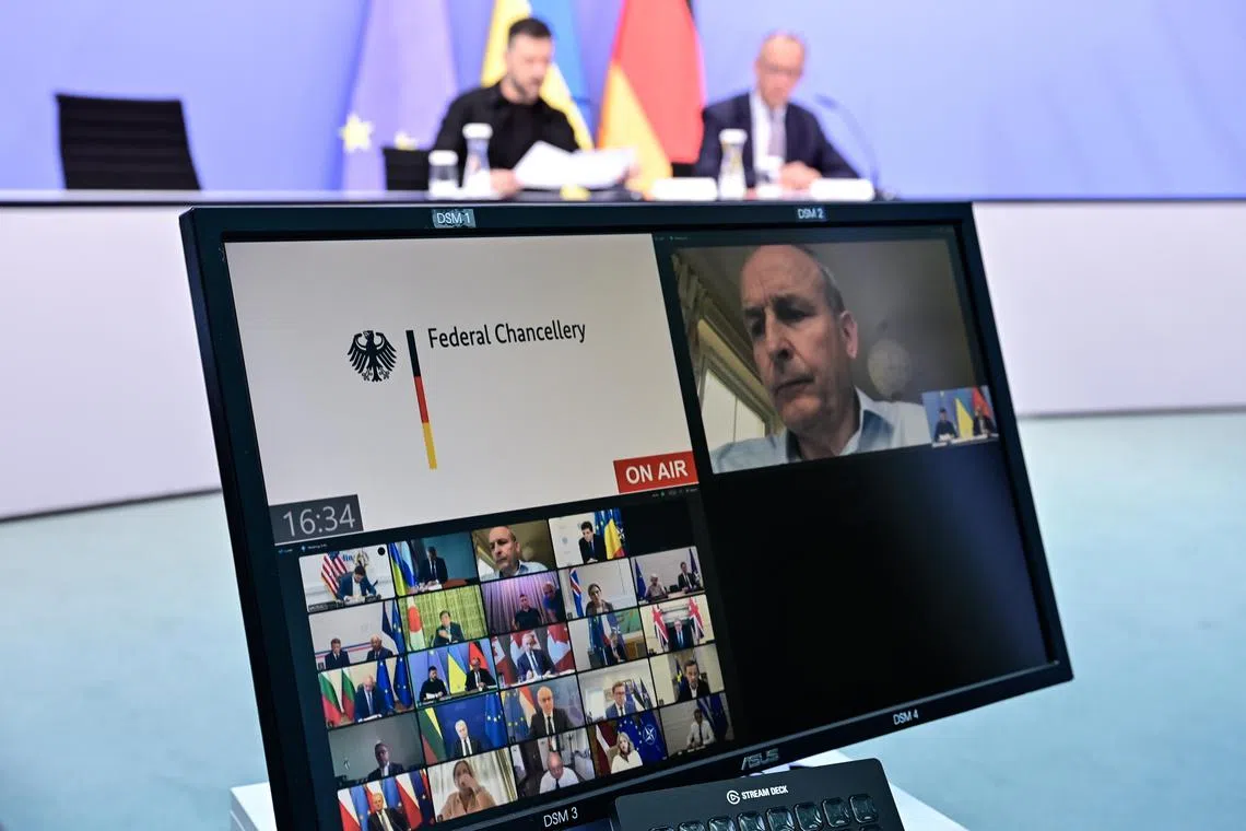Ukrainian President Volodymyr Zelensky (back, left) and German Chancellor Friedrich Merz (back, right) taking part in an Aug 13 online meeting with European and US leaders (on screen), in Berlin, Germany.