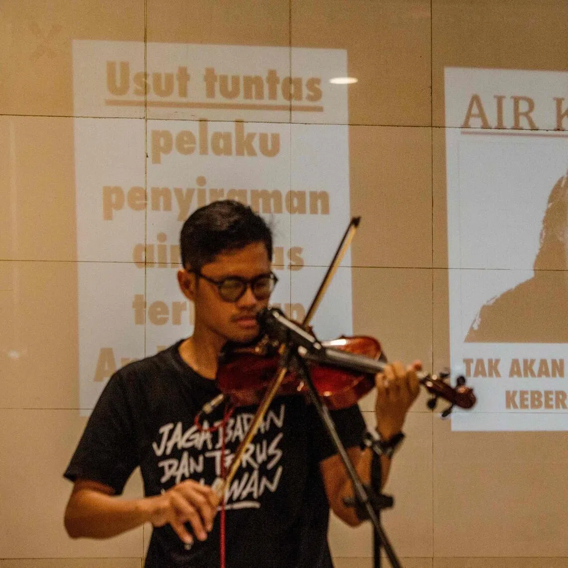 A local violinist performs during a demonstration in support of Andrie Yunus, a staff member of Indonesian human rights NGO KontraS, who was attacked with acid.