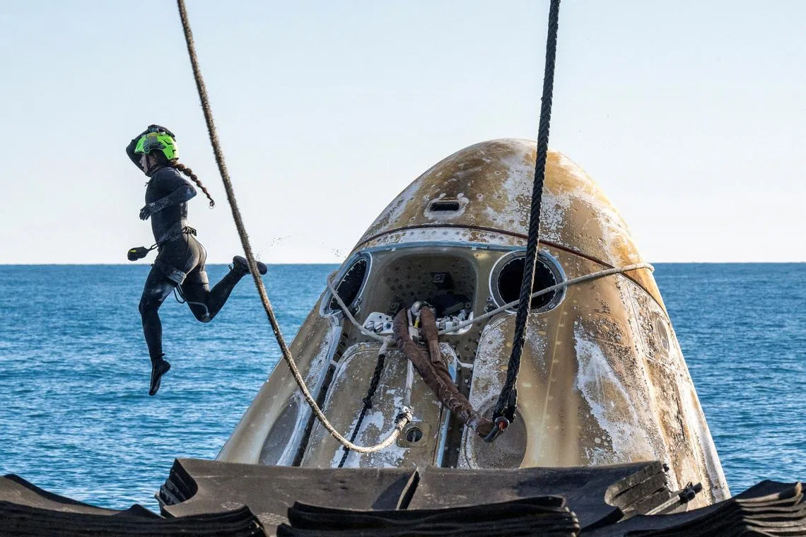 Support teams working around the SpaceX Dragon spacecraft shortly after it landed in the waters off the coast of Tallahassee, Florida, on March 18, 2025.