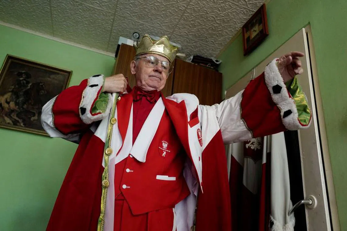 Andrzej \"Bobo\" Bobowski, known as \"the King of Polish fans\", puts on his occasional coat at his apartment in Warsaw, Poland June 6, 2018. Picture taken June 6, 2018. REUTERS/Kacper Pempel/File Photo