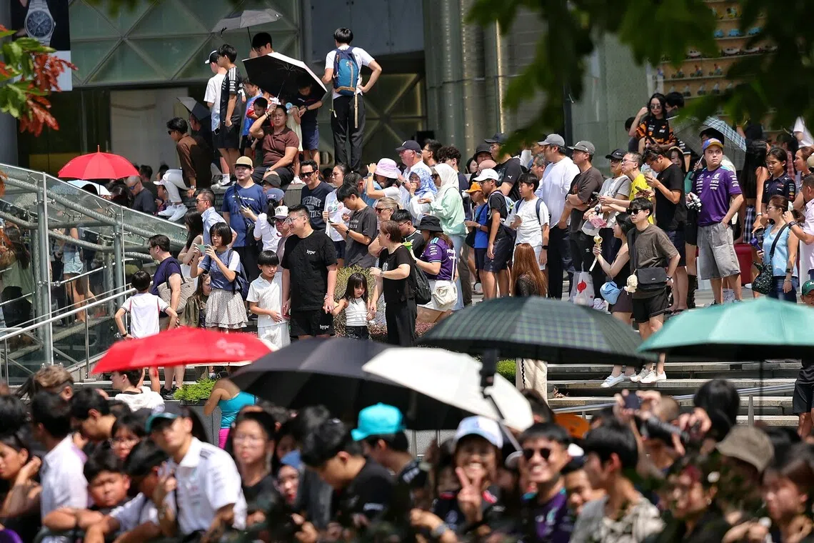 A crowd forming outside ION Orchard to catch a glimpse of Mercedes reserve driver Fred Vesti driving an F1 car down Orchard Road on Aug 30.