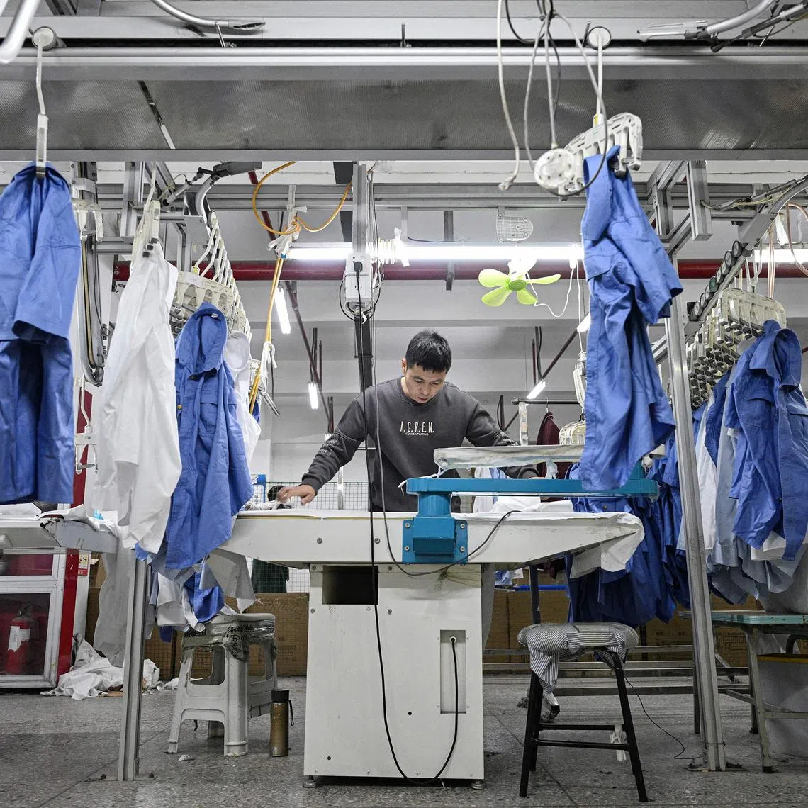 Employees work on a shirt production line at a clothing factory in Suqian, in eastern China's Jiangsu province on November 22, 2024. (Photo by AFP) / China OUT