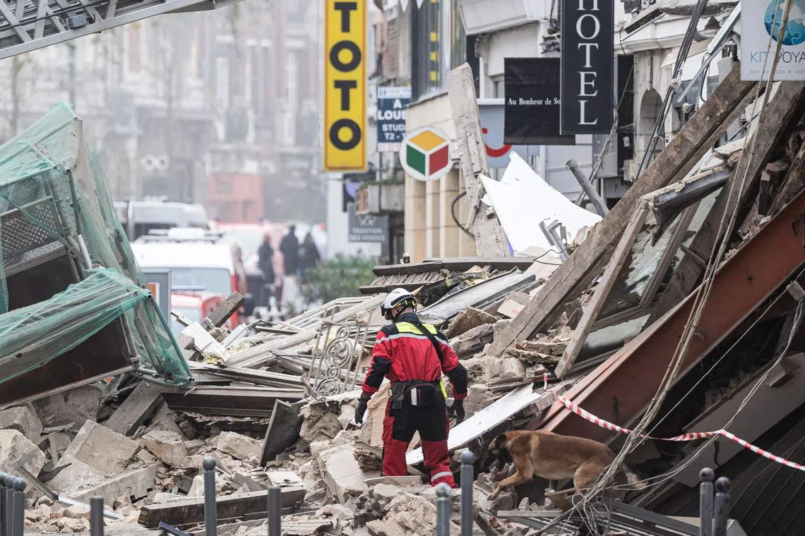 Firefighters inspect a collapsed building as they search for victims in the city of Lille, on Nov 12, 2022.