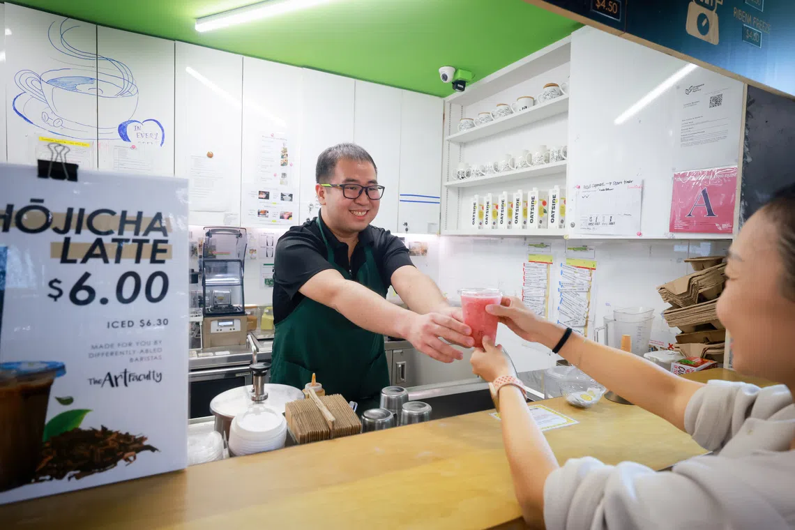Barista Caleb Lim, 31, who has autism spectrum disorder, serving a customer at the Enabling Village's Art Bar on Oct 2.