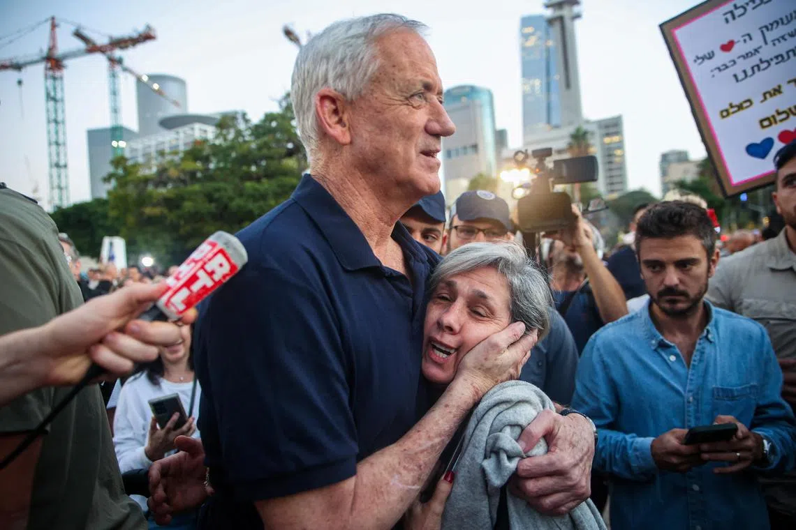 Israel war cabinet member Benny Gantz embraces a woman as he walks to meet with hostages family members, in Tel Aviv, Israel, on Nov 24.