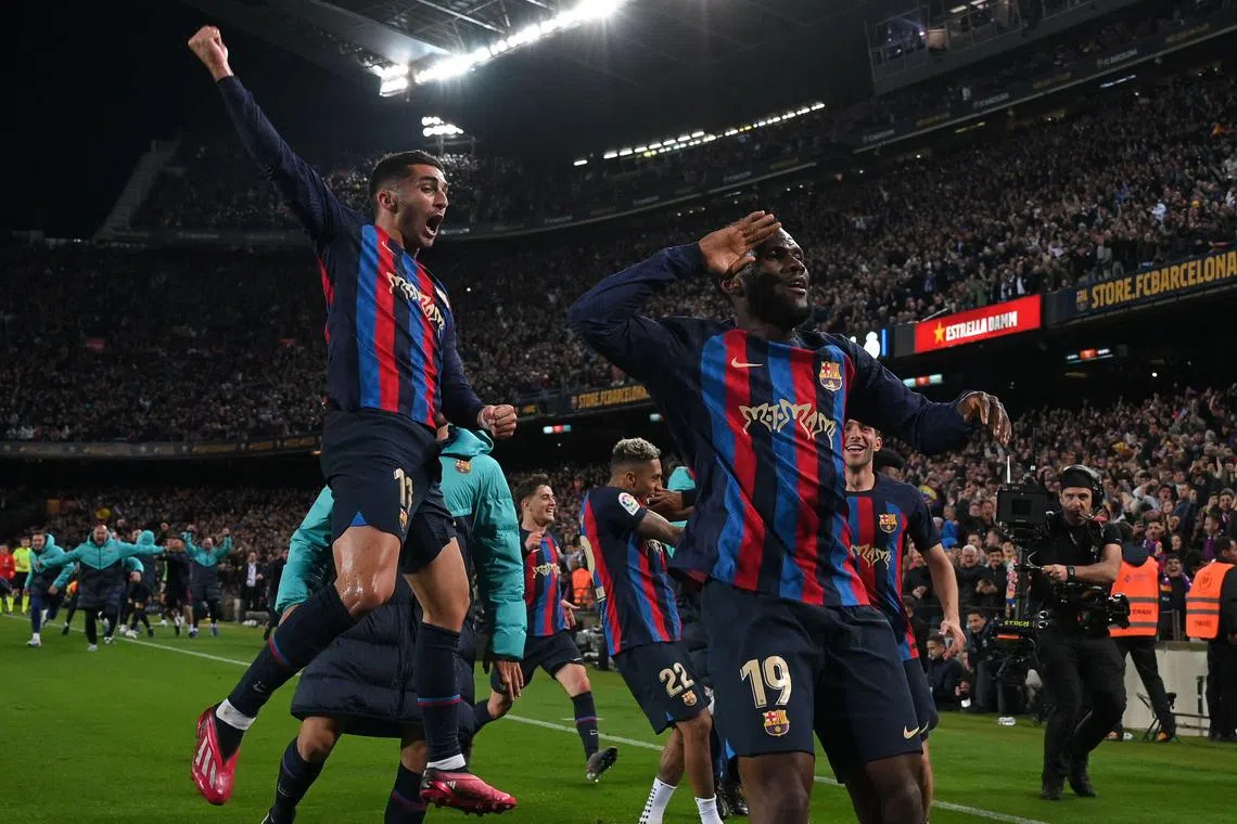 Barcelona midfielder Franck Kessie celebrating with teammates after scoring his team's second goal against Real Madrid at the Camp Nou stadium.
