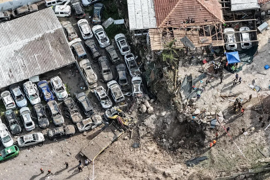 Israeli security and rescue personnel working at the impact site of a missile, near Eshtaol, Israel, on March 28.     