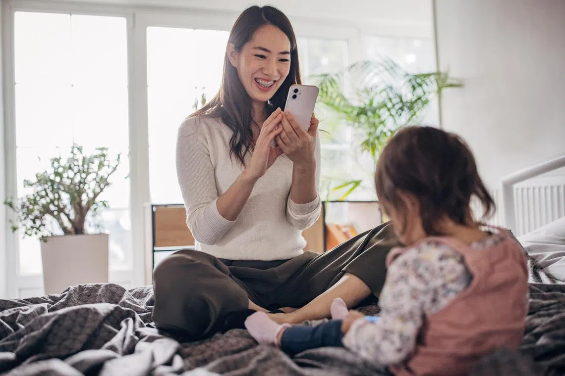 syshare29 - Mother is taking photos of her daughter while the girl is lying on the bed Credit: ISTOCKPHOTO