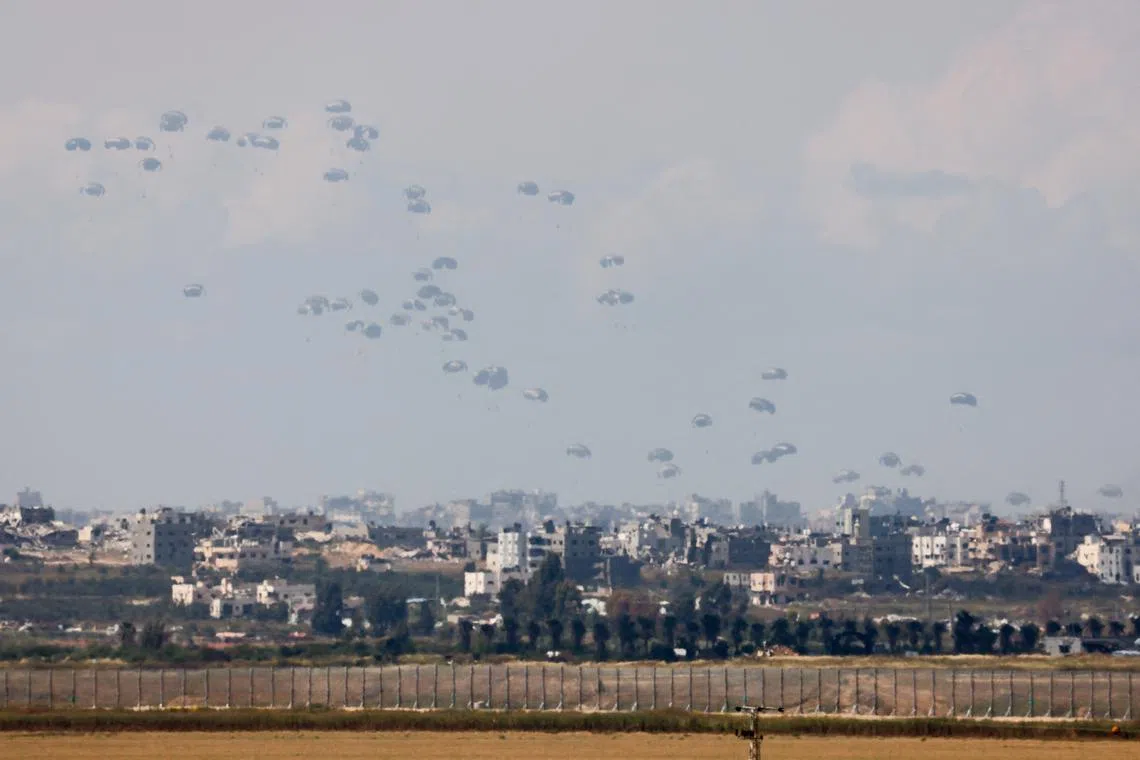 Humanitarian aid falls through the sky towards the Gaza Strip after being dropped from an aircraft, amid the ongoing conflict between Israel and the Palestinian Islamist group Hamas, as seen from Israel, April 9, 2024. REUTERS/Amir Cohen