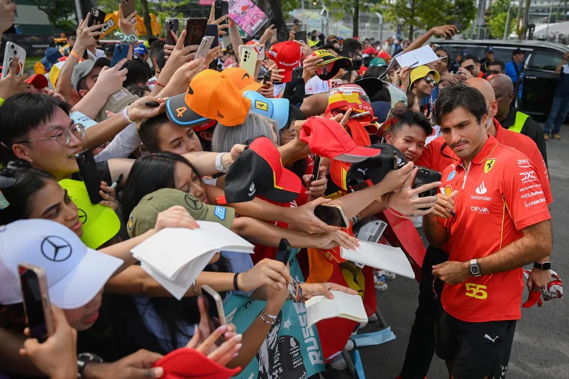 Ferrari's Carlos Sainz Jr. greeting fans before entering the paddock at the F1 Pit Building on September 20, 2024. 
