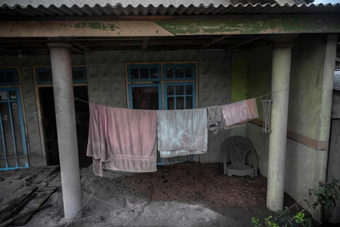 This picture shows towels hanging outside a house covered with ash following a volcanic eruption by Mount Semeru at Kajar Kuning village in Lumajang on Dec 5, 2022. 