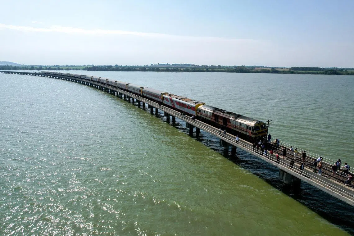 Tourists enjoy after a train stops at the middle of Pasak Jolasid Dam in Lopburi province.
