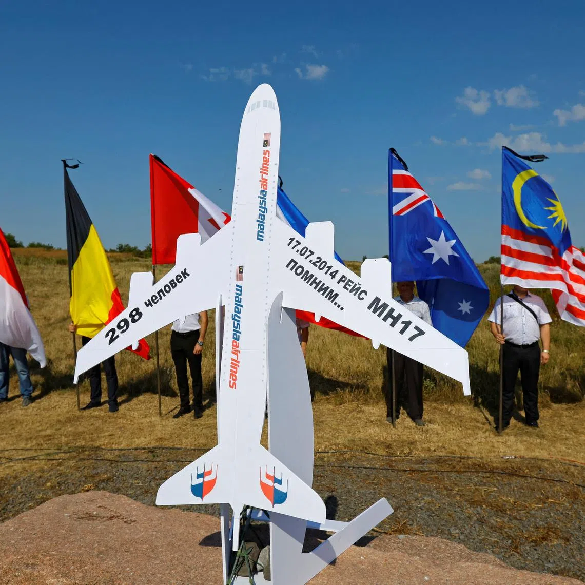 FILE PHOTO: People hold flags at a memorial to victims of the Malaysia Airlines Flight MH17 plane crash during a ceremony marking the 10th anniversary of the accident, near the village of Hrabove (Grabovo) in the Donetsk region, Russian-controlled Ukraine, July 17, 2024. REUTERS/Alexander Ermochenko/File Photo