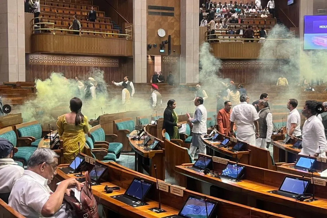 Yellow smoke is seen drifting around the Lower House of India's Parliament in this screengrab.