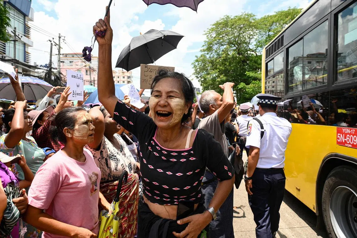 Relatives celebrate around a bus carrying prisoners being released from Insein prison in Yangon on April 17.