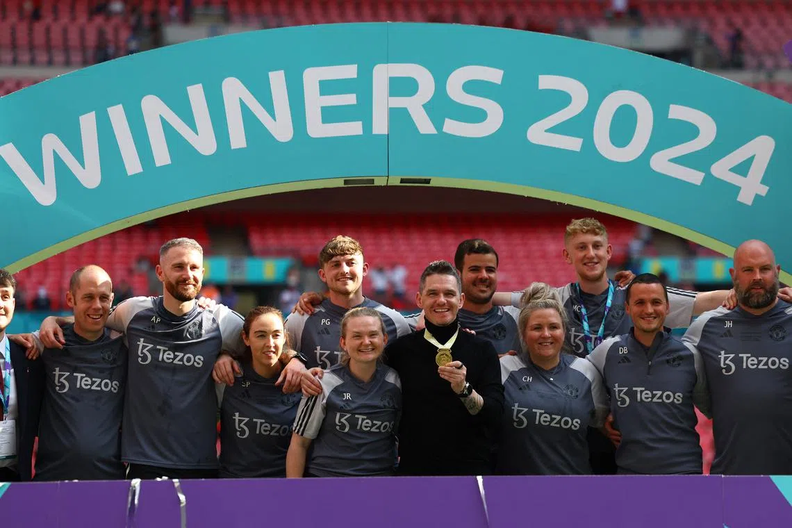 Soccer Football - Women's FA Cup - Final - Manchester United v Tottenham Hotspur - Wembley Stadium, London, Britain - May 12, 2024 Manchester United manager Marc Skinner poses with his medal and staff after winning the women's FA Cup REUTERS/Molly Darlington