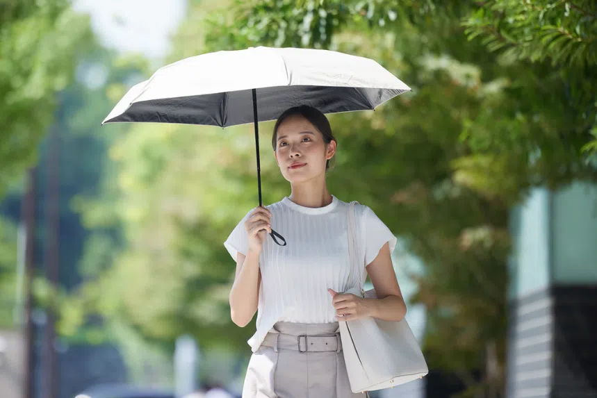 Best UV umbrellas in Singapore: Woman carrying a UV umbrella on a sunny day
