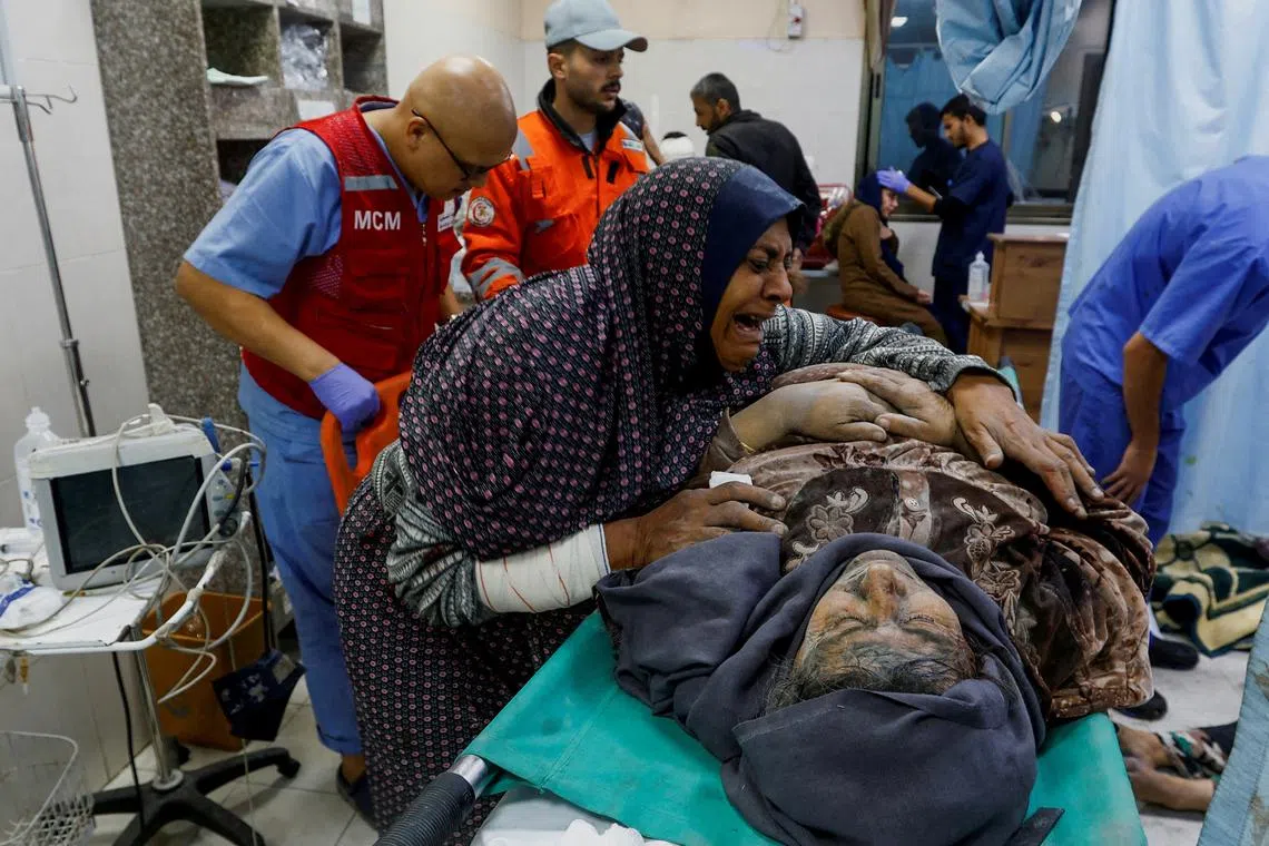 FILE PHOTO: A Palestinian woman reacts next to a wounded man at Nasser hospital following Israeli strikes, amid the ongoing conflict between Israel and Palestinian Islamist group Hamas, in Khan Younis in the southern Gaza Strip, December 9, 2023. REUTERS/Ibraheem Abu Mustafa/File Photo