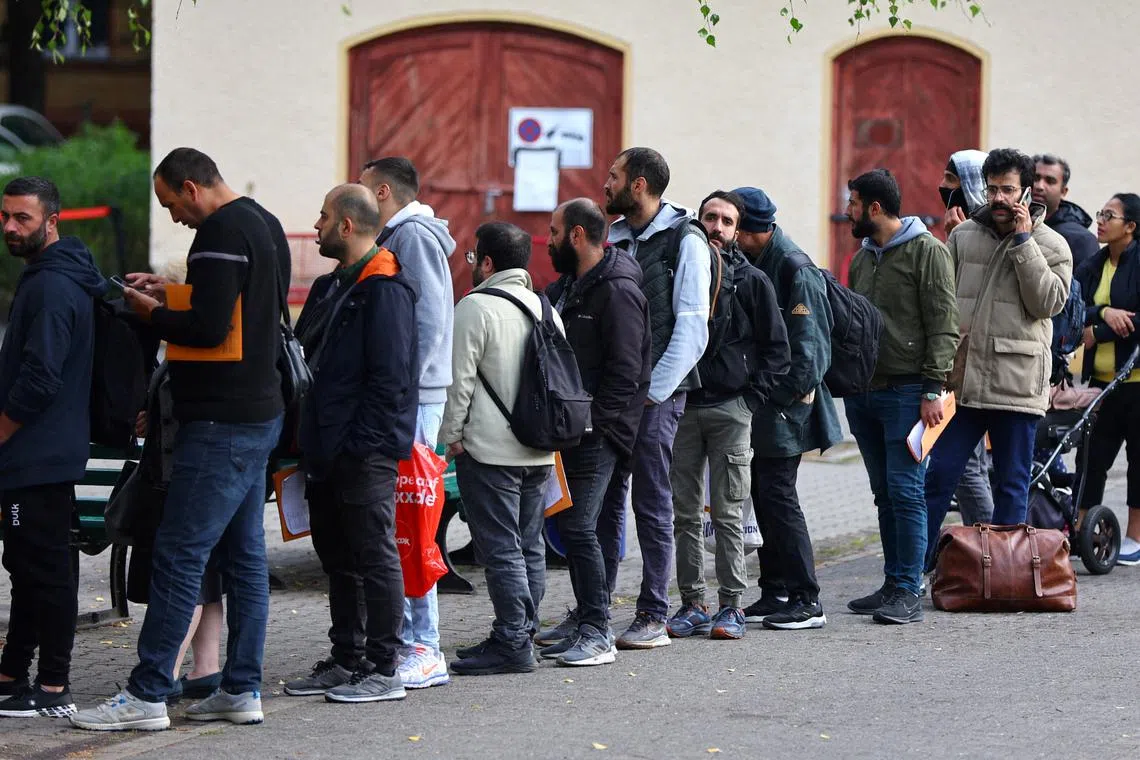FILE PHOTO: Migrants queue in a waiting area to be escorted to a registration office at the arrival centre for asylum seekers in Reinickendorf district, Berlin, Germany, October 6, 2023. REUTERS/Fabrizio Bensch/File Photo
